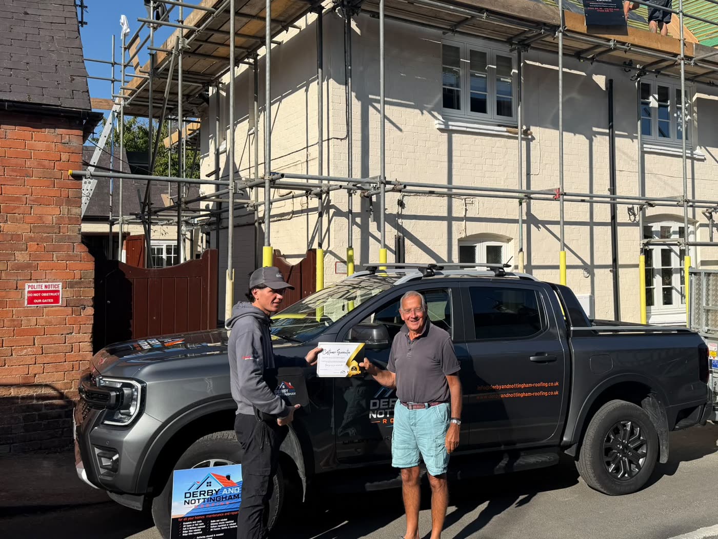 A Derby & Nottingham Roofing customer being handed their written workmanship guarantee